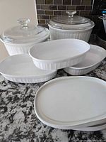 Full group view of casseroles, oval dishes, and plastic lids