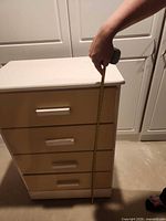 Front view of chest showing four drawers and tape measure indicating height