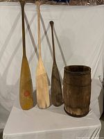 Front view of three paddles and wood keg