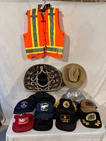 Overall group shot showing vest, sombrero, cowboy hat, hard hat, Tilley hat group of caps