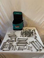 Overview of Makita tool bag and spread of assorted wrenches on table