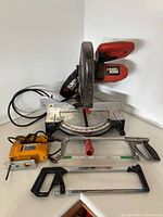 Front view of miter saw, jigsaw, two hacksaws