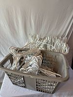 Two baskets filled with white plastic hangers