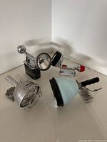 Four views showing both handheld spotlights with mounting bases