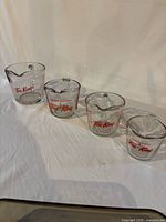 Four Fire-King measuring cups in graduated sizes