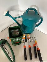 All items grouped showing watering can, spreader, sprinkler and three hand tools