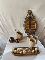 Full group overview of mirror, wooden tray with decorative spheres, ceramic vases, woven baskets