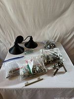 Group shot showing drawer pulls in bags, wall sconces, door handle and hardware
