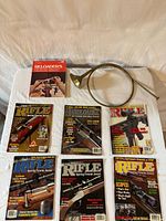 All items laid out: 5 Rifle magazines, 1 Handloader magazine, Reloaders book, brass hunting horn