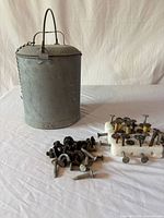 Overall lot showing water can, group of date nails on foam block and loose nails