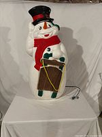 Front view of plastic blow-mold snowman with sign and power cord visible
