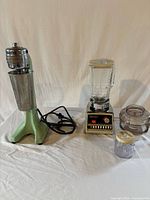 Full view of Hamilton Beach drink mixer with mixing cup and Osterizer blender with attachments