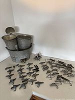 boil pot holding two sap buckets next to pile of metal spiles