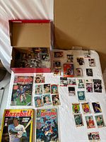 Overview showing shoe box of loose cards, sticker albums, and laid-out sleeved cards