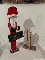 Full view of wooden Santa figure and birch log candle stand