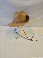 front angled view showing crown, brim and leather strap