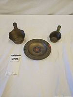 Full set of two brass silk irons and matching bowl displayed