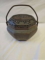 Front view of incense burner with handle raised and pierced lid visible