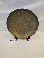 Front view of brass bowl on stand showing etched dragon design