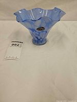 Overall view of blue and white ruffled glass bowl with label