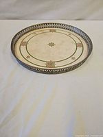 Full view of circular tray showing metal rim and porcelain center