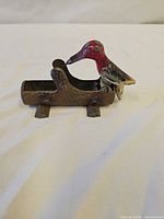 Side view of cast iron woodpecker toothpick picker showing entire form