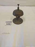 Full view of brass desk bell on pedestal base