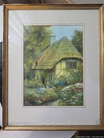Full view of framed painting showing cottage scene and surrounding frame