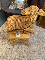 Front view of wicker lamb on wooden stool
