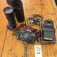 Overall lot view: camera, zoom lens with case, flash with box, cable