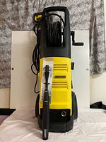 front view showing Kärcher pressure washer, hose reel, handle and packaged spray lance