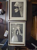 Both framed etchings side by side showing subjects, frames, mats