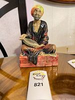 Front view of Mendicant figurine on table