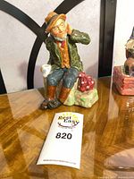 Front view of seated Owd Wilum figurine showing colors and pose