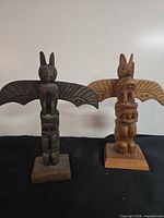 Front view of both signed wooden totem poles