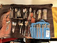 Full lot showing stacked spoons, forks, serving pieces and knife roll
