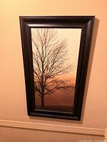 Vertical tree silhouette print in dark wood frame