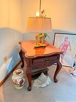 Cabriole-leg end table front view showing drawer, carved apron and glass-protected scalloped top