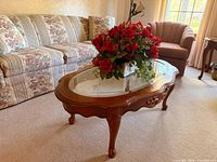 Oval glass-top cherry coffee table in living room setting