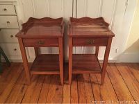 Front view of both wooden nightstands side by side on wood floor, showing single drawer and lower shelf design.
