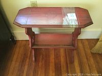 Top view of wooden book stand showing octagonal shaped top with water marks and taped area.