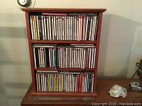 Full view of the wooden 3-shelf unit filled with classical CDs, showing size and overall condition.