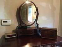 Wooden reproduction shaving mirror with oval mirror and three small drawers, digital clock and wooden box on table