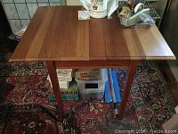 Full view of cherry table with both drop leaves down, showing rectangular top and straight legs.