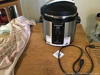 Cuisinart electric pressure cooker showing model on front and power cord.