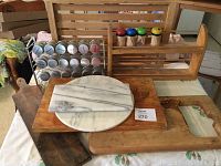 Photo of three wooden cutting boards, two white marble slabs, and wooden spice racks on a table