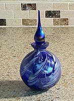 Full view of cobalt blue perfume bottle with stopper