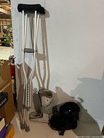 Crutches leaning against wall beside walking boot components