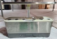Stainless AeroGarden unit with LED hood and pod openings visible