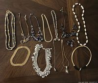 All twelve necklaces laid out on tabletop
